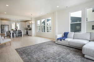 Open-concept living space featuring wood-finish flooring, recessed lighting, and multiple large windows