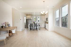 Open-concept living space featuring wood-finish flooring, recessed lighting, and large windows