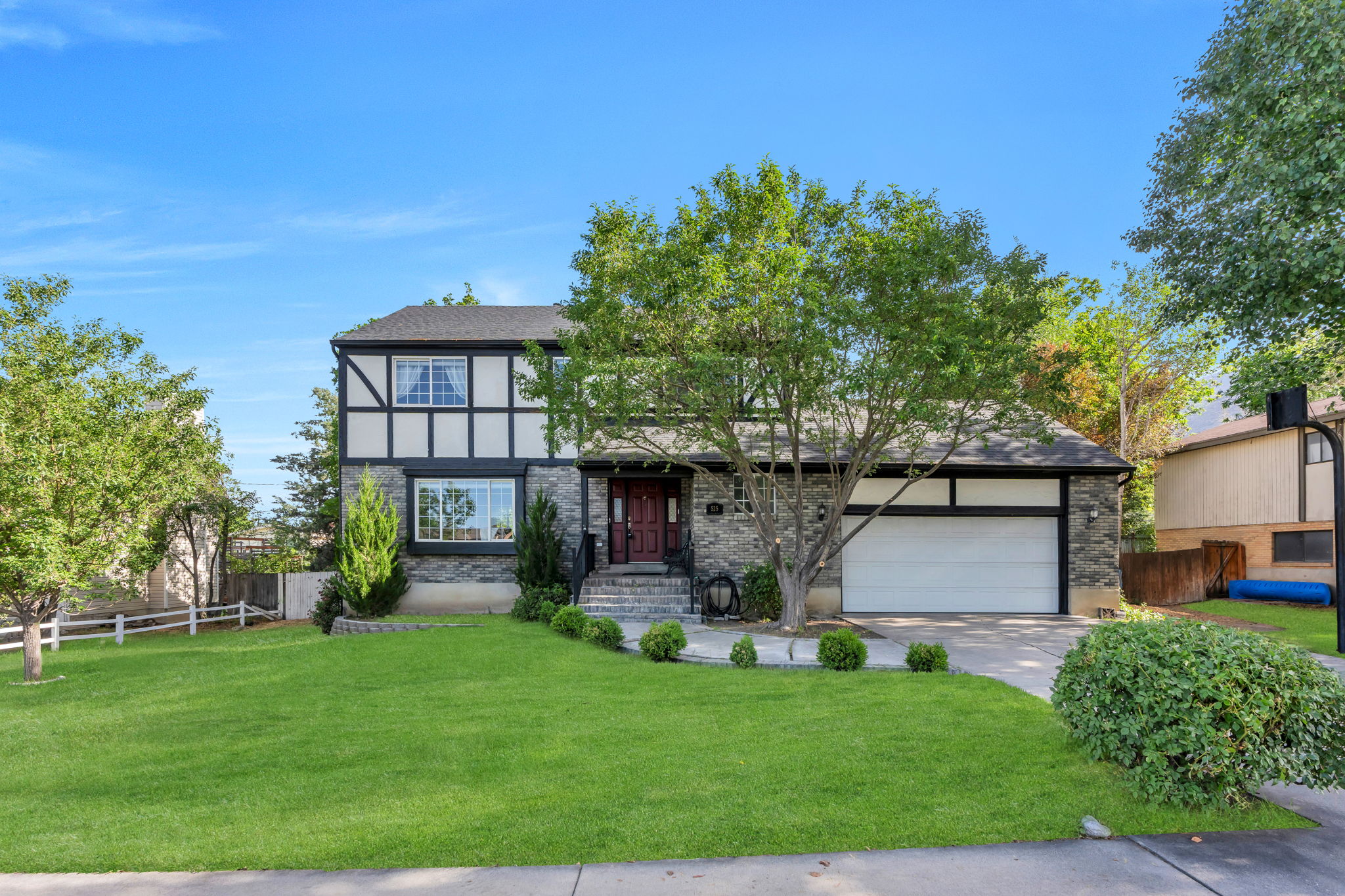 Tudor-style exterior featuring stone veneer, decorative half-timbering, and a prominent dark roof