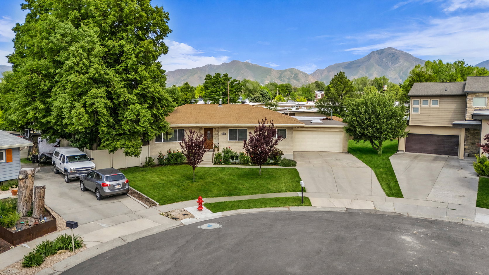Single-story residence featuring a concrete driveway, attached garage, and a manicured lawn