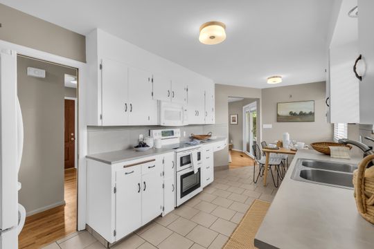 Kitchen featuring white cabinetry, light countertops, and tile flooring