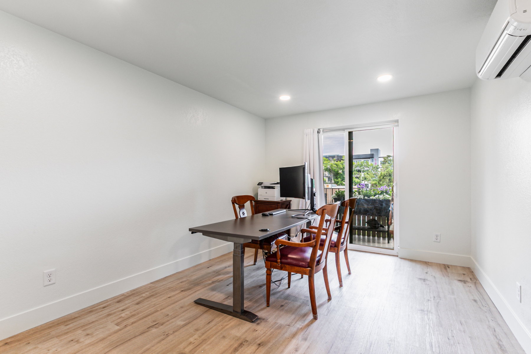 Room featuring wood-finish flooring, recessed lighting, and a sliding glass door providing outdoor access