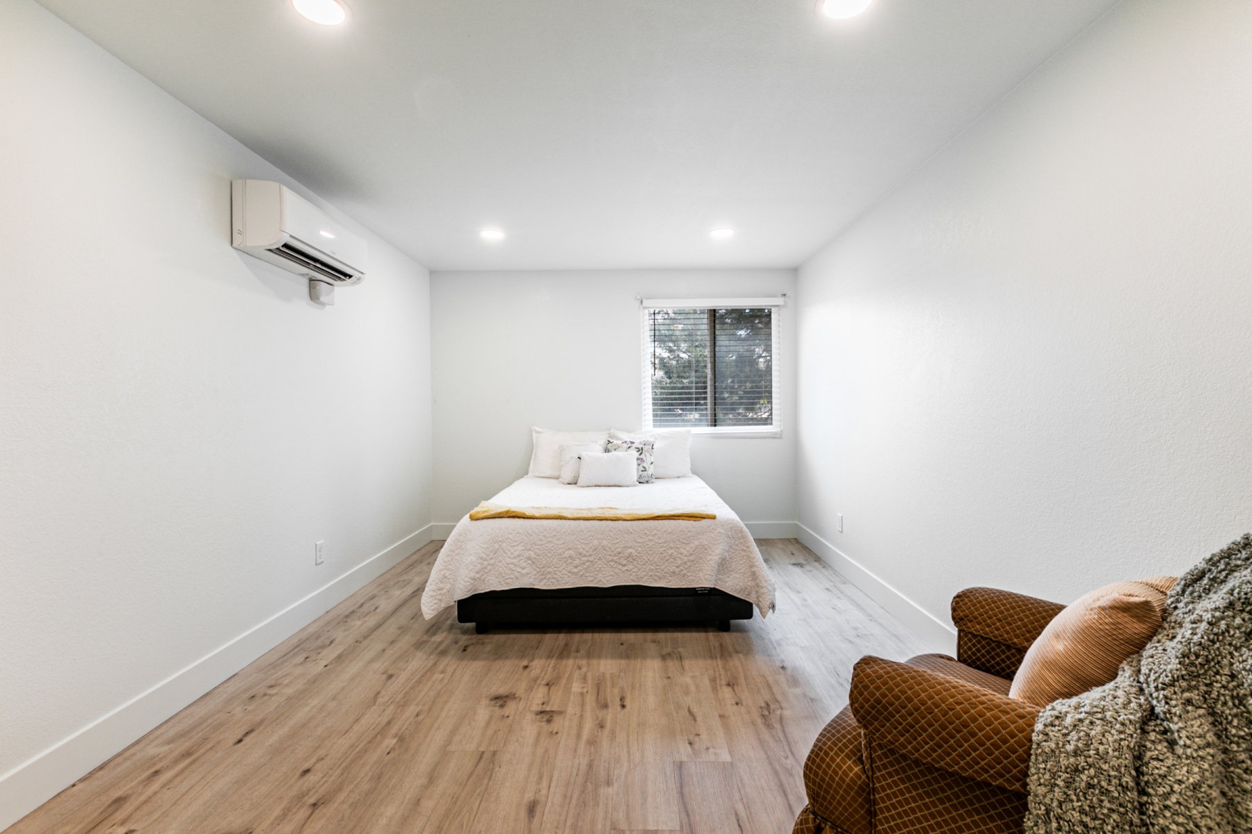 Room featuring wood-finish flooring, recessed lighting, and an installed wall-mounted air conditioning unit