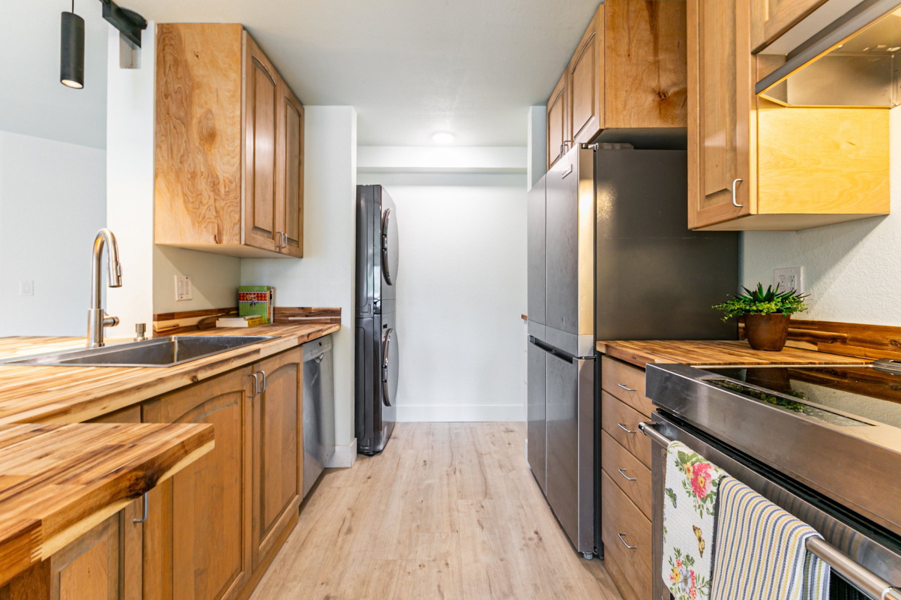 Kitchen featuring wood-finish countertops, wood cabinetry, stainless steel appliances, and wood-finish flooring