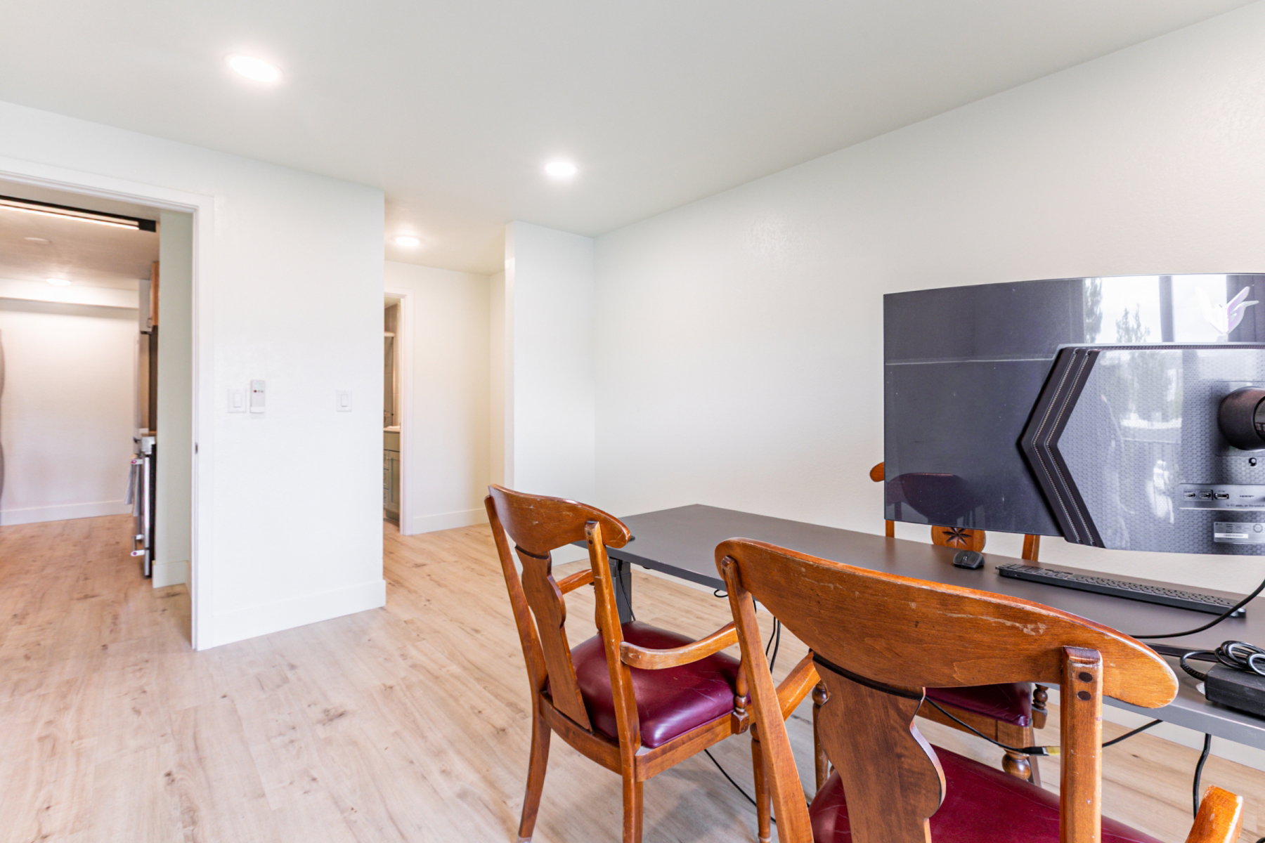 Bright interior space featuring light wood-finish flooring, white walls, and recessed ceiling lighting