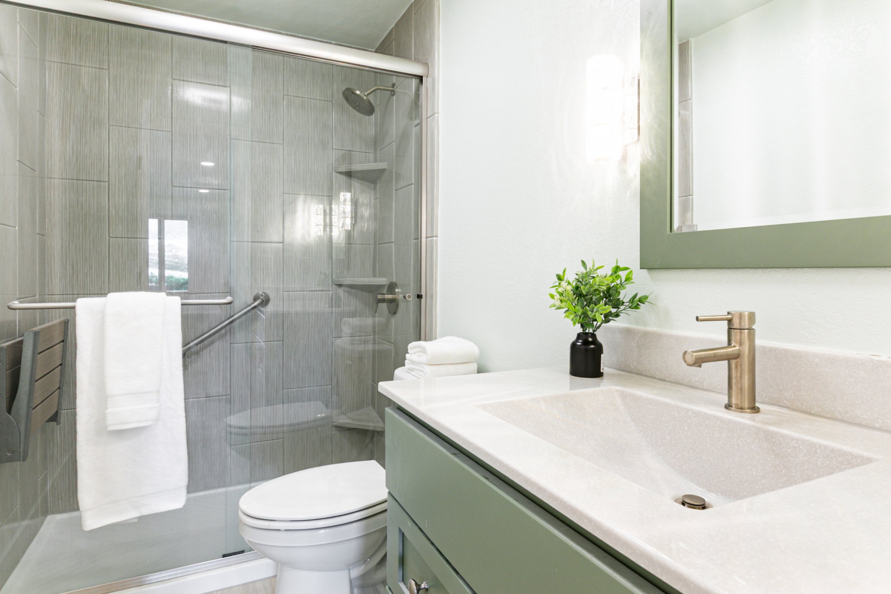 Contemporary bathroom featuring a walk-in shower with vertical tile surround and glass enclosure