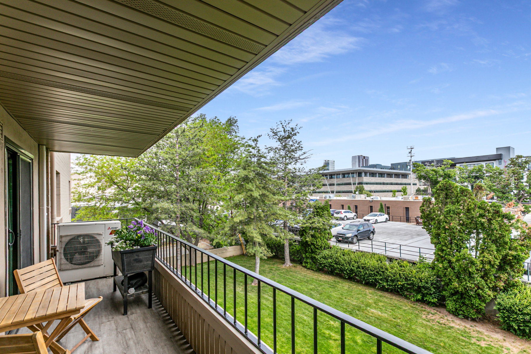 Private balcony featuring wood-finish flooring and a black metal railing