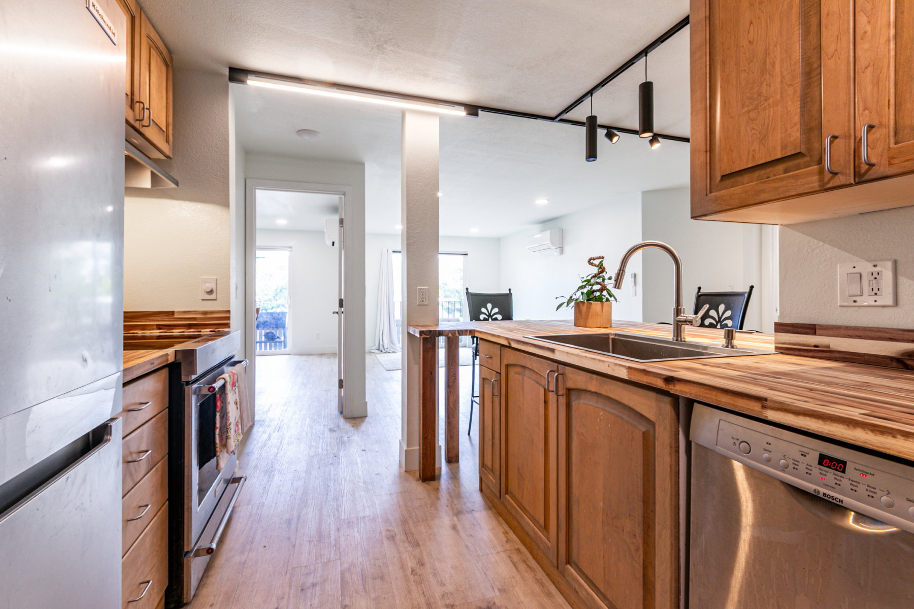 Kitchen featuring wood-finish flooring, wood cabinetry with brushed nickel hardware, and wood countertops