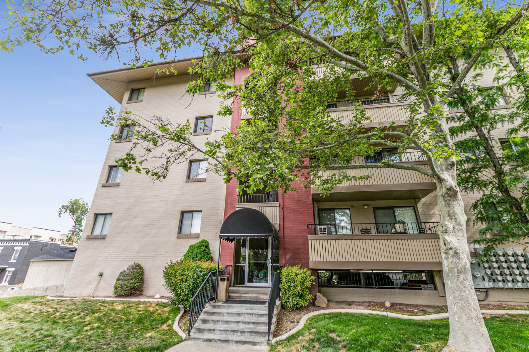 Multi-story building exterior featuring brick and textured panel siding