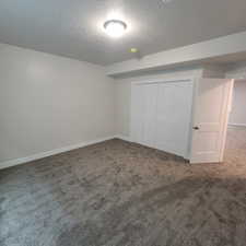 Room featuring grey carpeting, white walls, and a ceiling-mounted light fixture