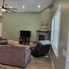 Living area featuring vaulted ceilings, wood-finish flooring, and recessed lighting