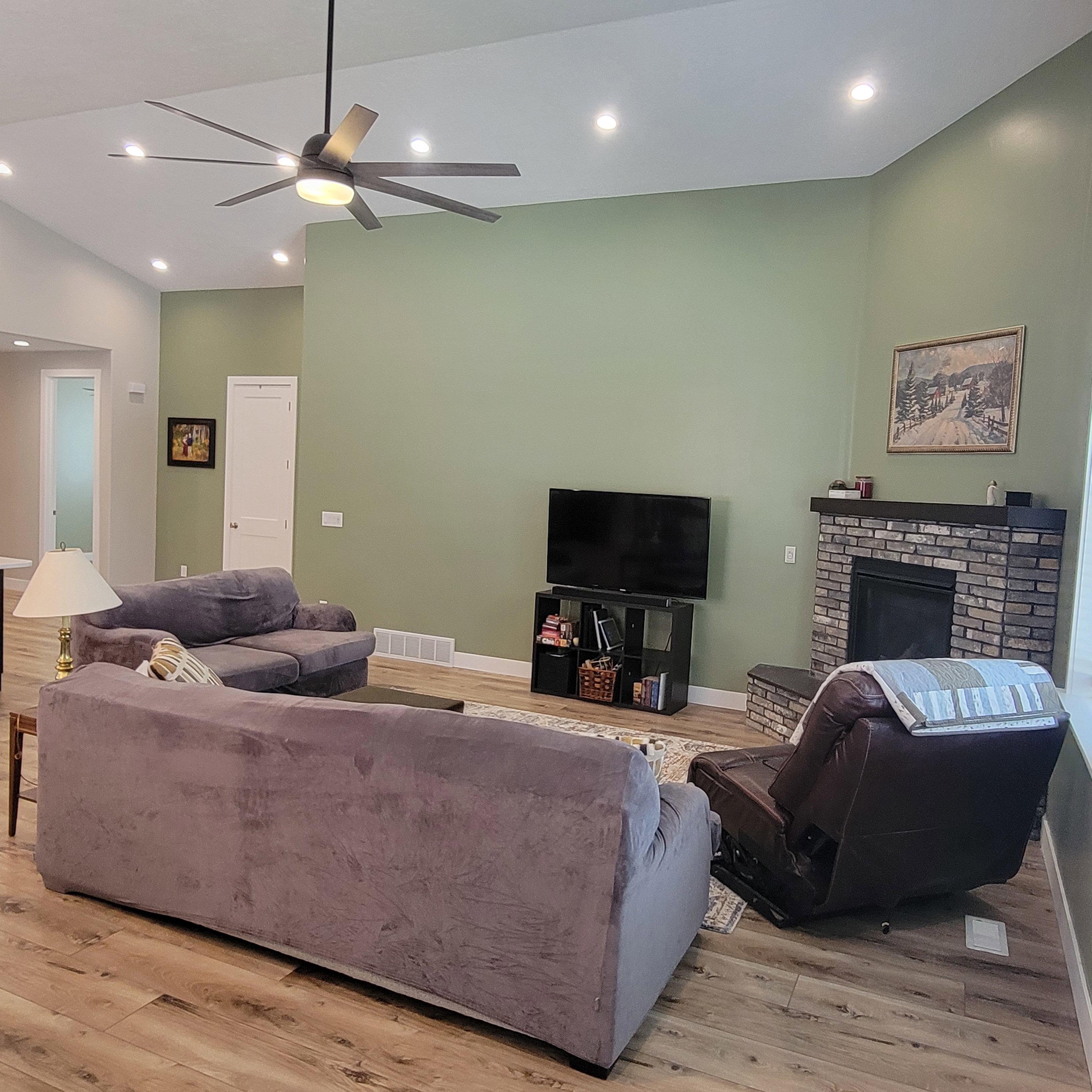 Spacious living area featuring vaulted ceilings, recessed lighting, and wood-finish flooring