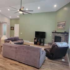 Spacious living area featuring vaulted ceilings, recessed lighting, and wood-finish flooring