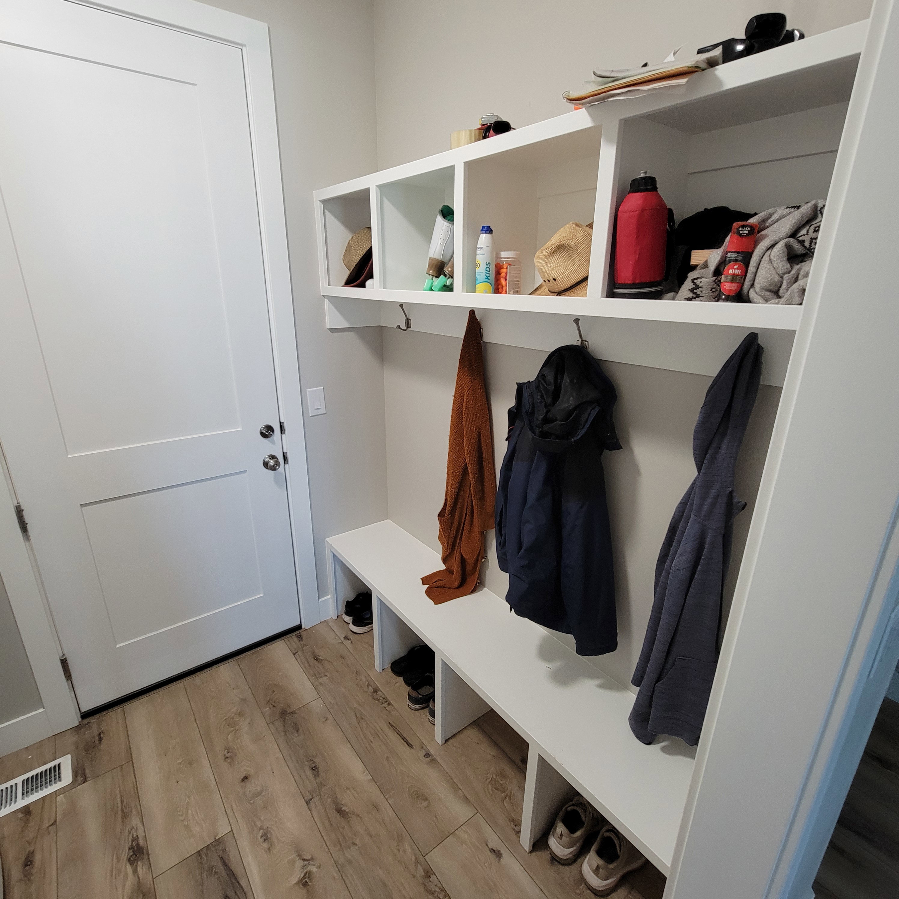 Built-in mudroom storage featuring bench seating, overhead cubbies, and coat hooks
