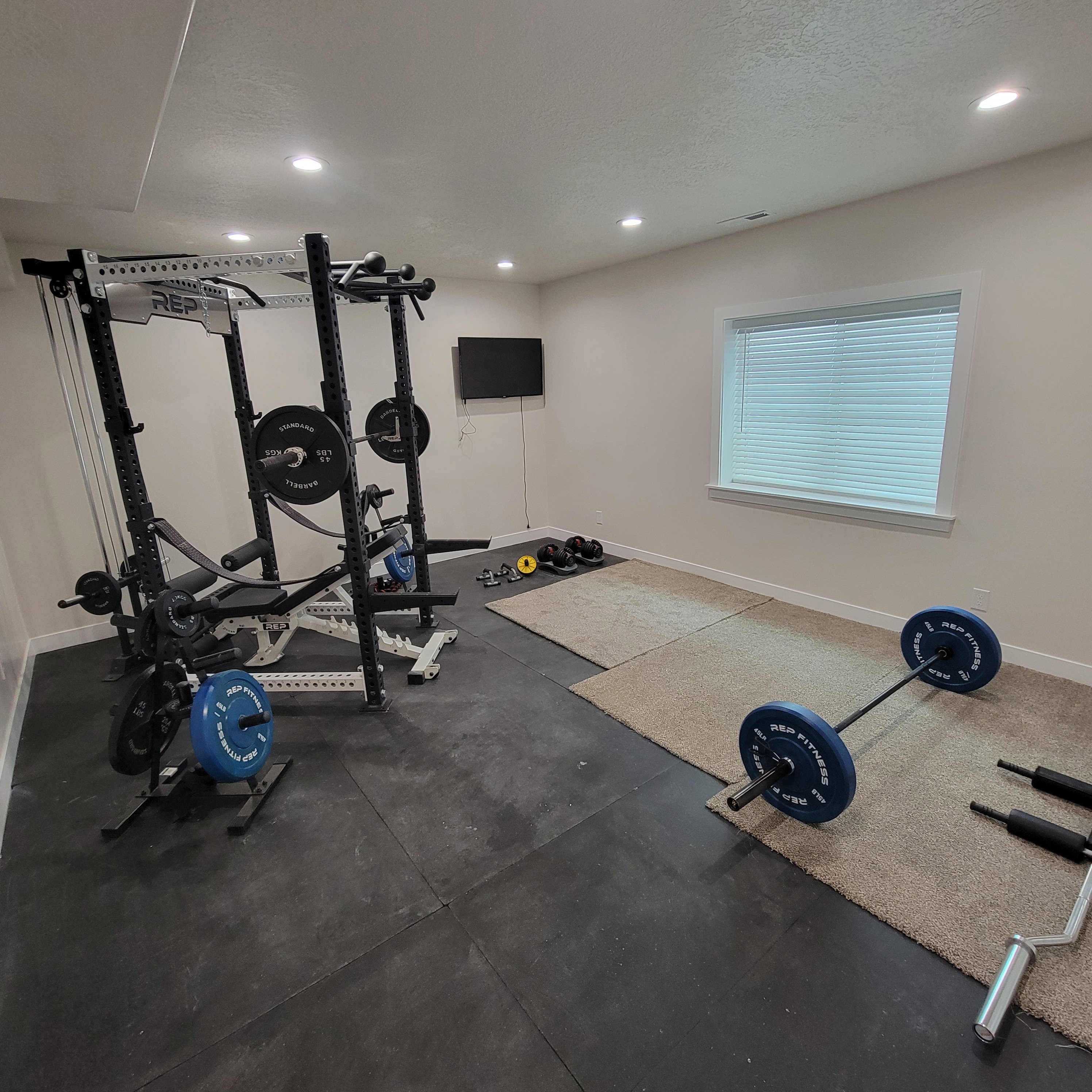 Dedicated room featuring recessed lighting, a window with blinds, and a wall-mounted television