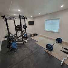 Dedicated room featuring recessed lighting, a window with blinds, and a wall-mounted television