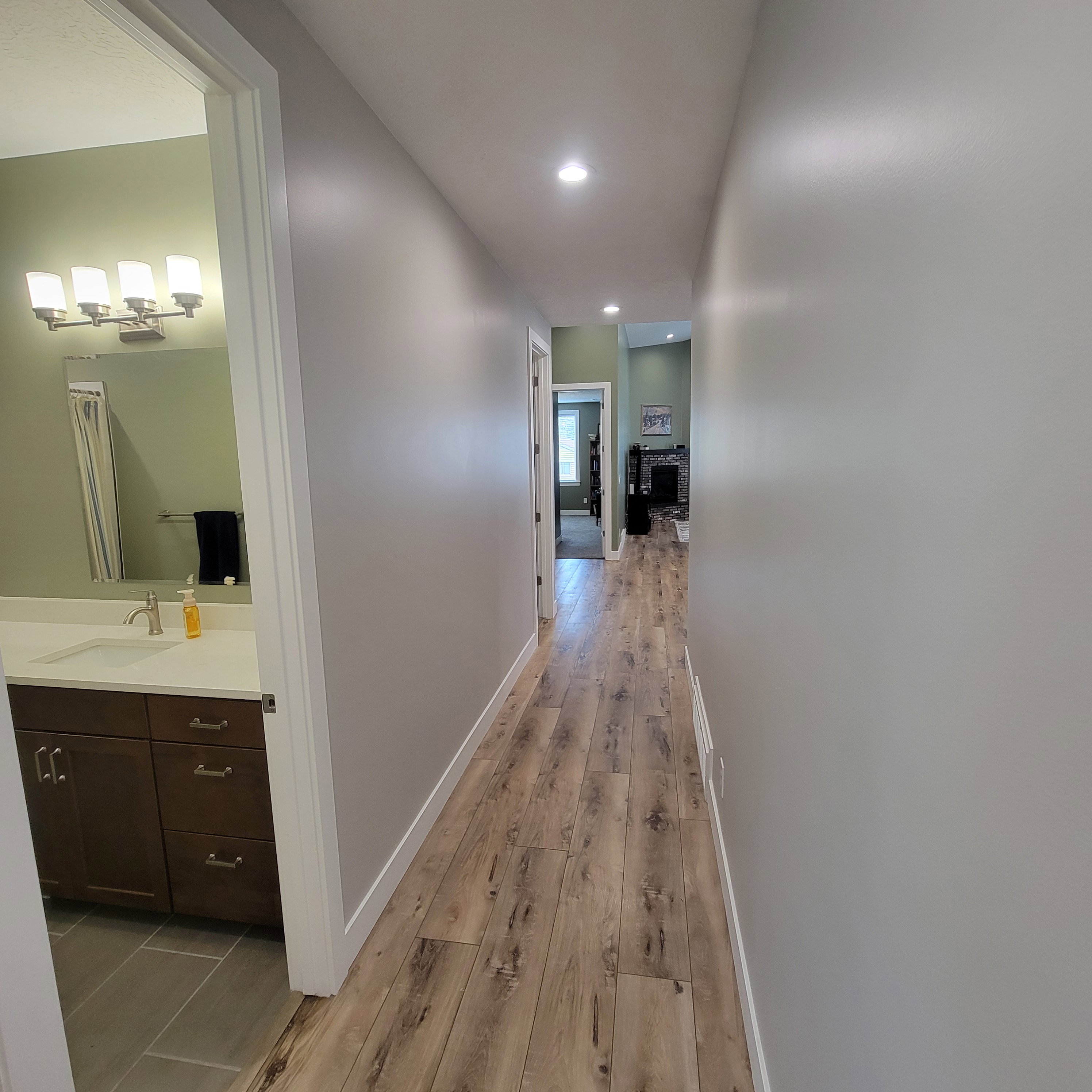 Hallway with wood-finish flooring and recessed lighting