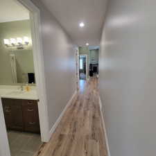 Hallway with wood-finish flooring and recessed lighting