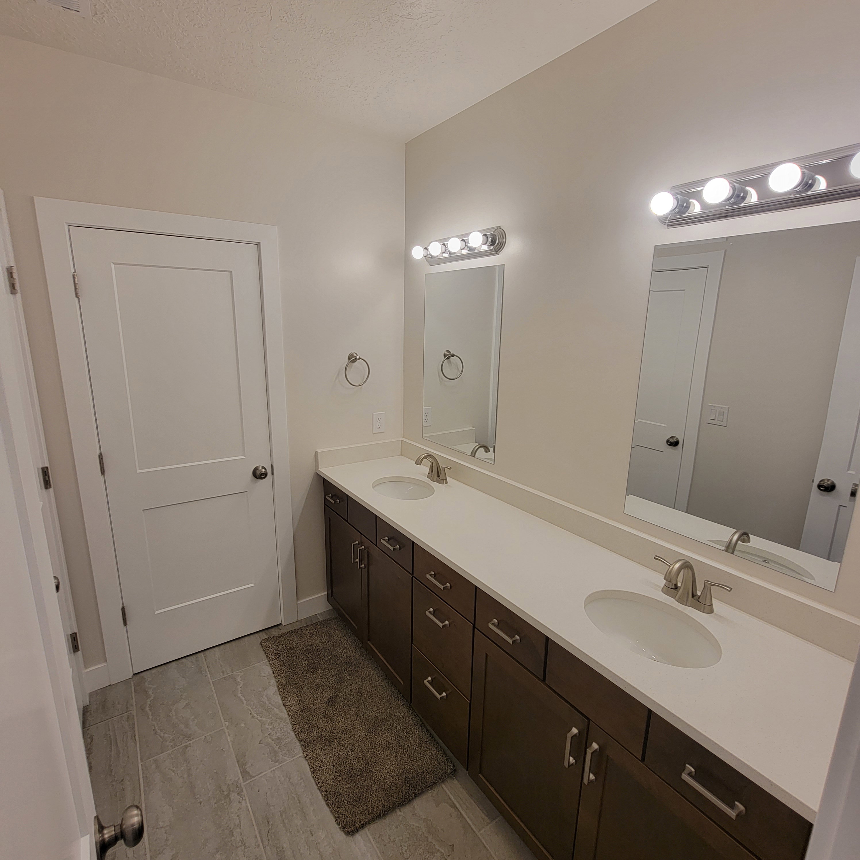 Double vanity featuring white countertops, undermount sinks, and brushed nickel fixtures