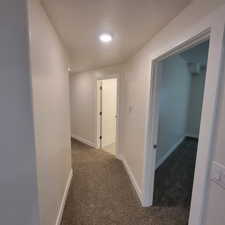 Neutral-toned hallway featuring recessed ceiling lighting and plush carpeting