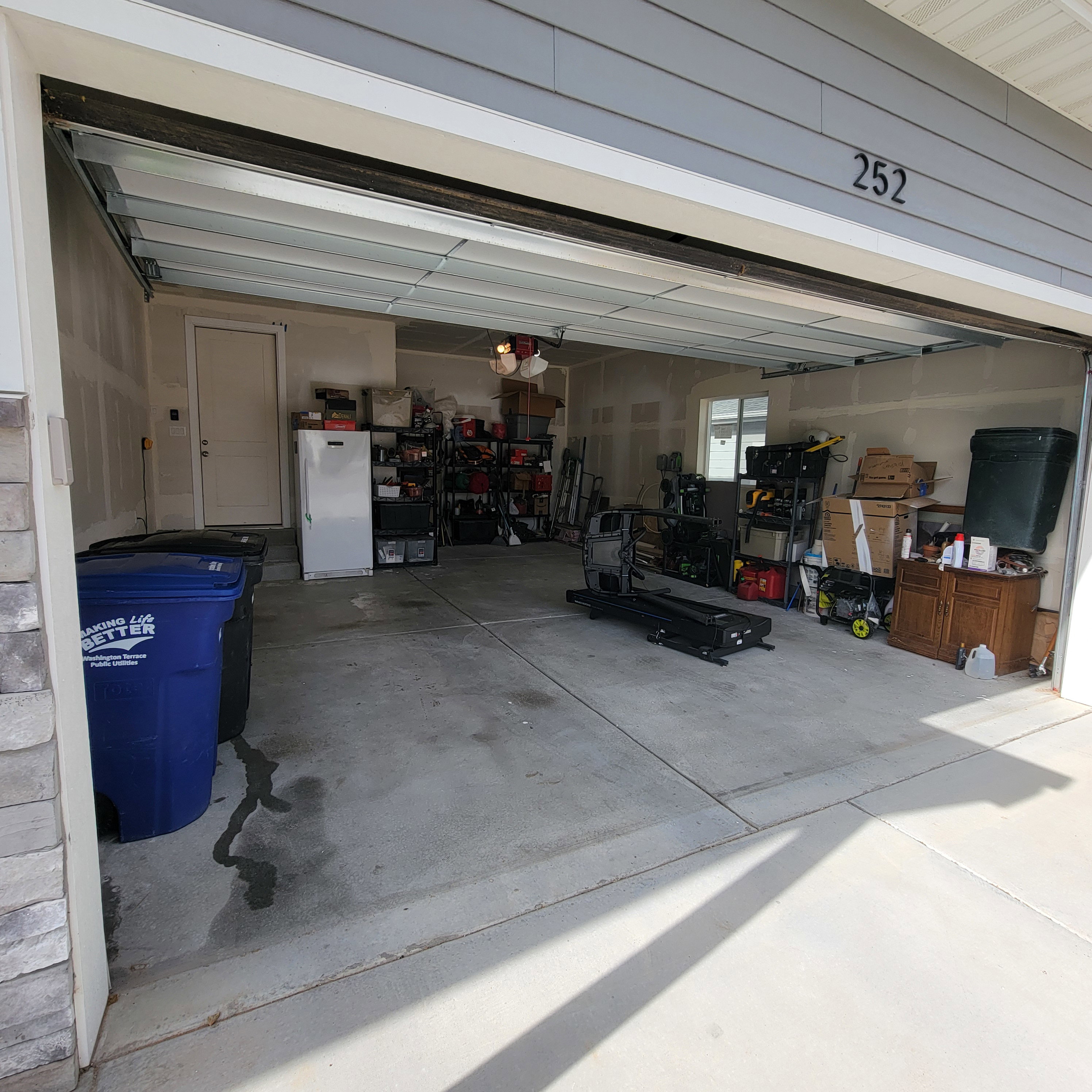 Spacious garage featuring a concrete floor, an interior access door, a side window for natural light, and exposed ceiling joists