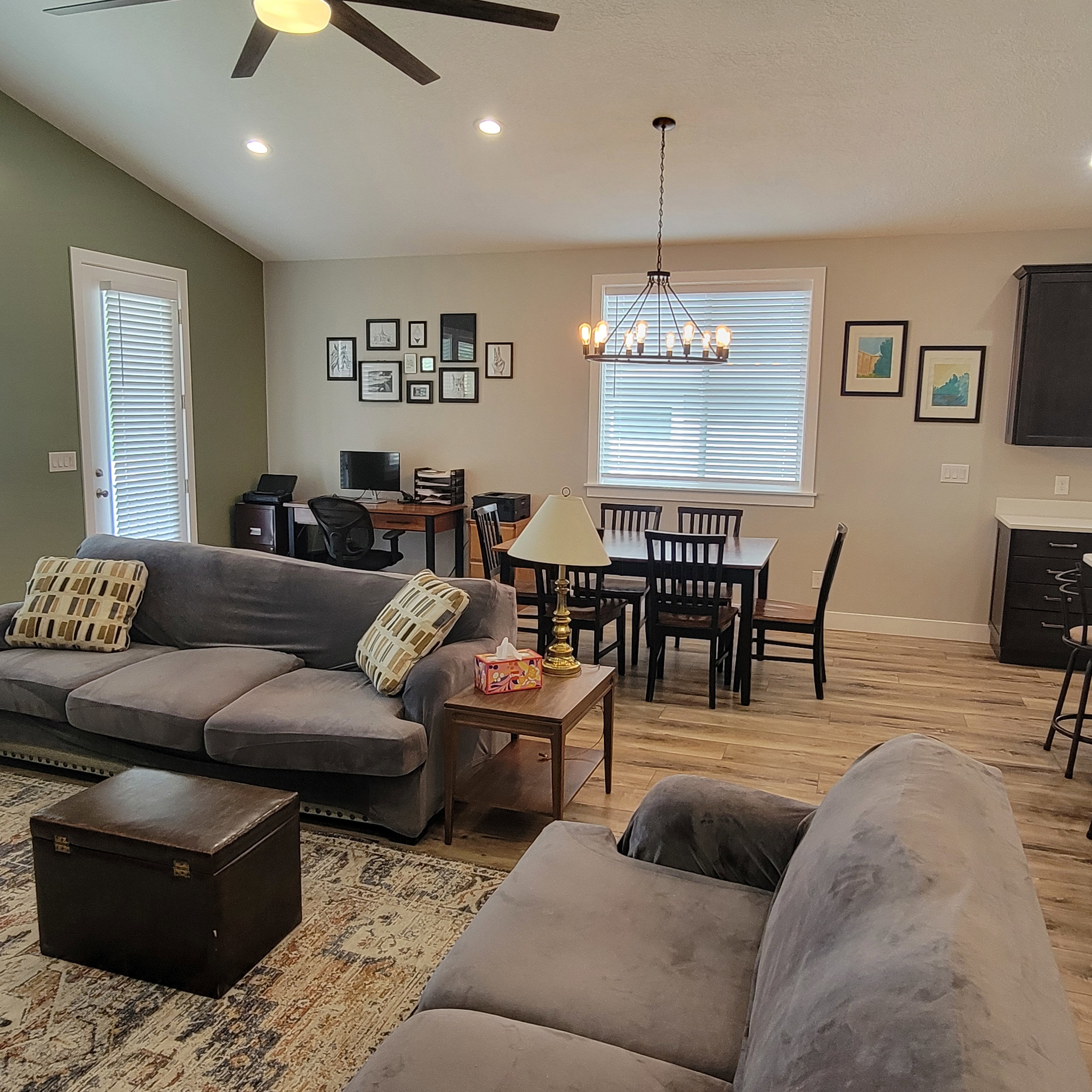 Open-concept living space featuring wood-finish flooring, recessed lighting, and a vaulted ceiling with a ceiling fan