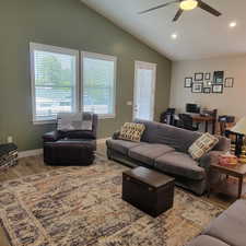 Vaulted ceiling living space with wood-finish flooring