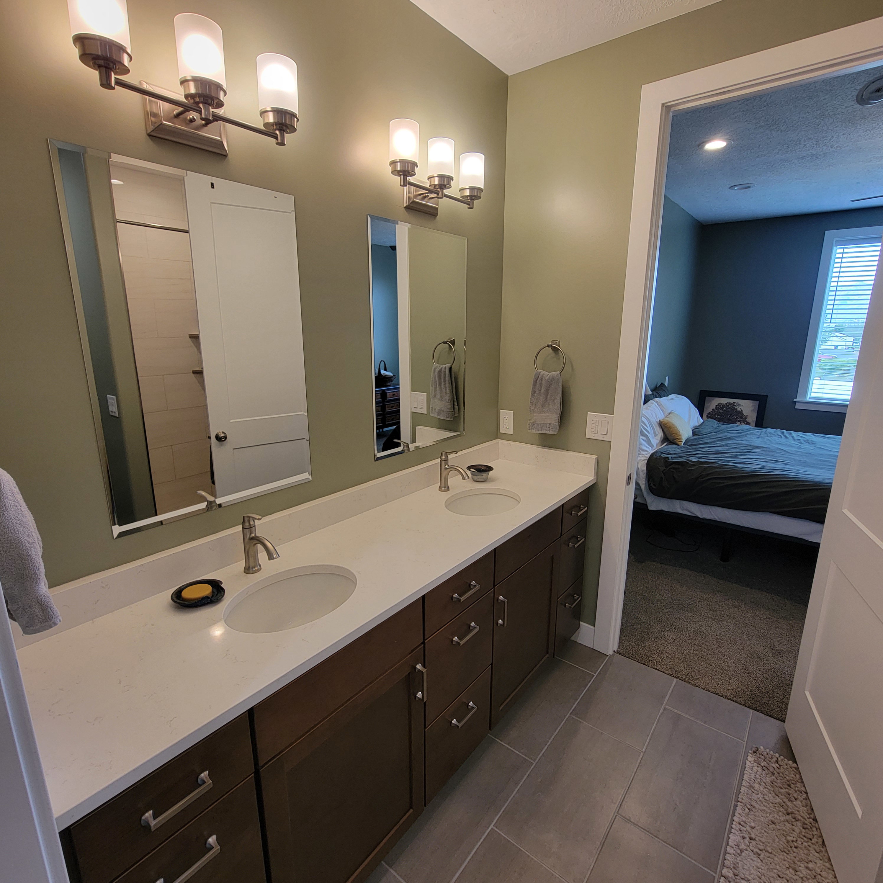 Double vanity featuring integrated sinks and brushed nickel faucets