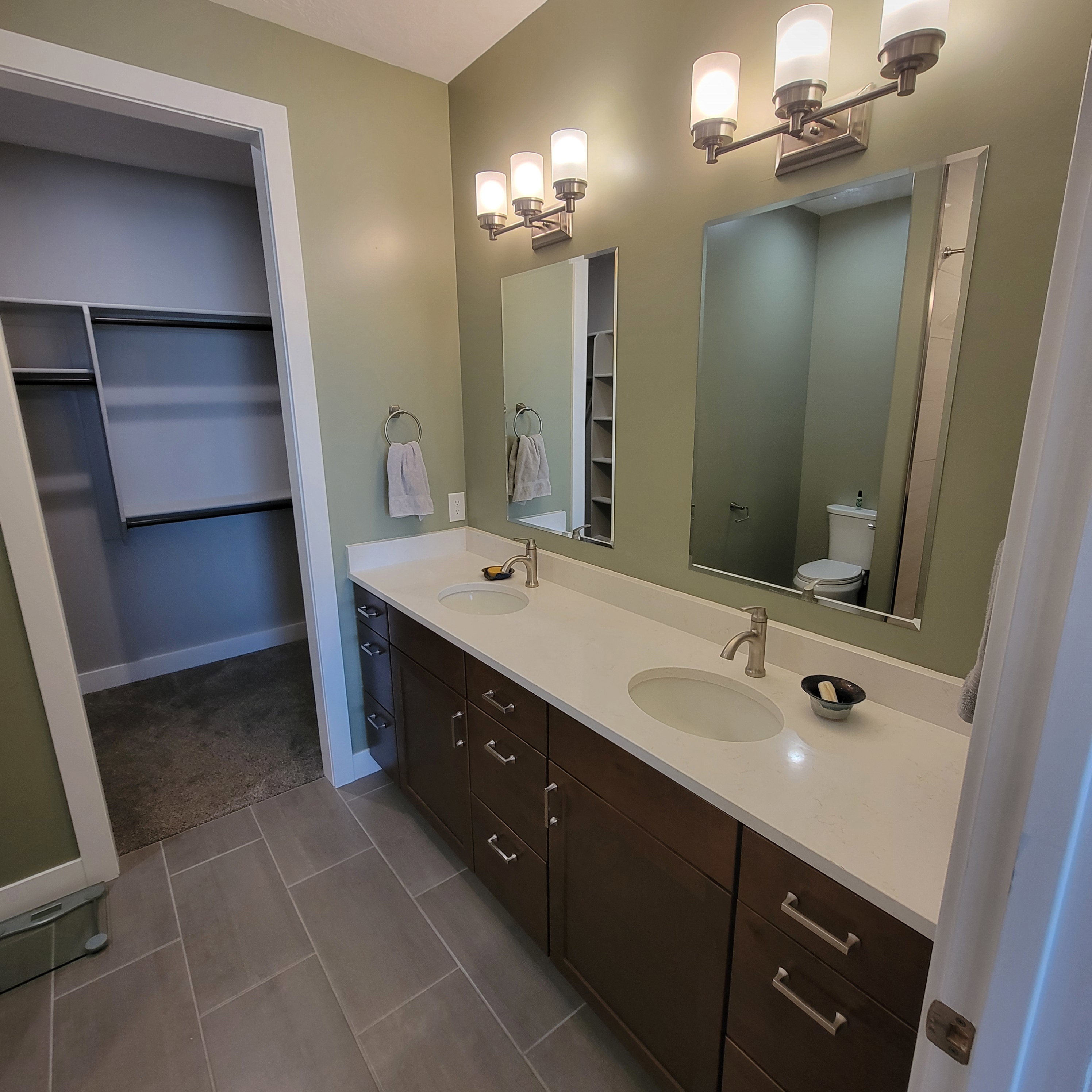 Dual vanity with white countertops, undermount sinks, and brushed nickel fixtures