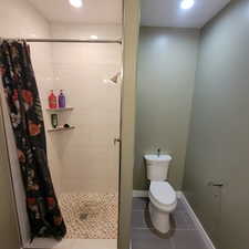 Walk-in shower with light-toned rectangular wall tiles and a herringbone-patterned floor