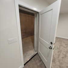 Solid-core door revealing a concrete-floored space with concrete walls