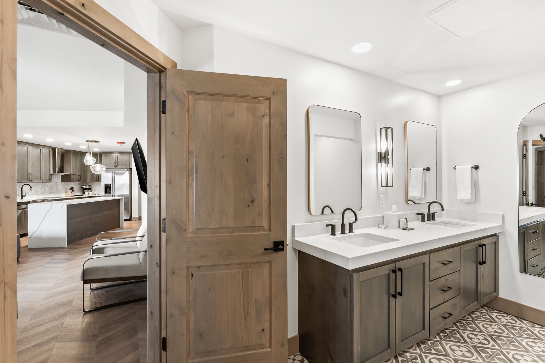 Contemporary bathroom featuring a double vanity with matte black fixtures and a patterned tile floor