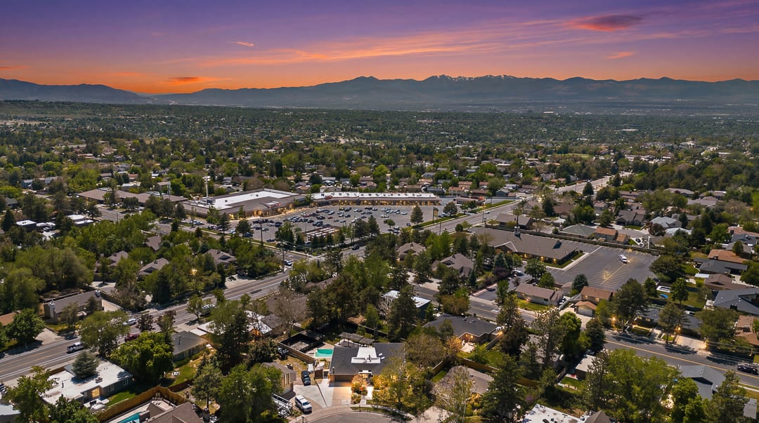 Expansive aerial perspective showcasing a residential neighborhood with distant mountains