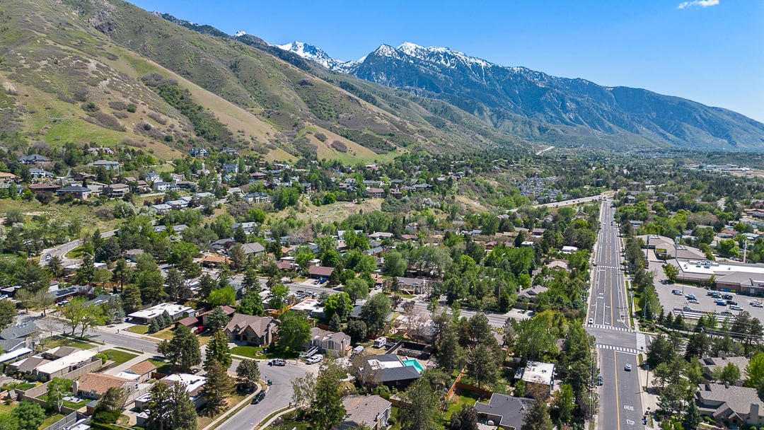 Expansive residential area featuring established homes, mature trees, and mountainous terrain