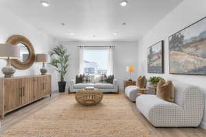 Spacious living area featuring light wood-finish flooring and recessed lighting