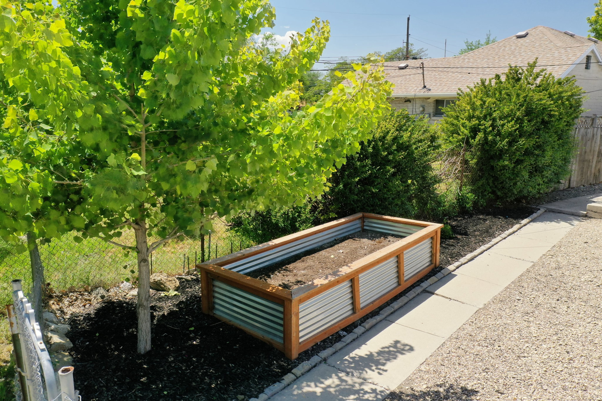 Raised garden bed with corrugated metal and wood framing