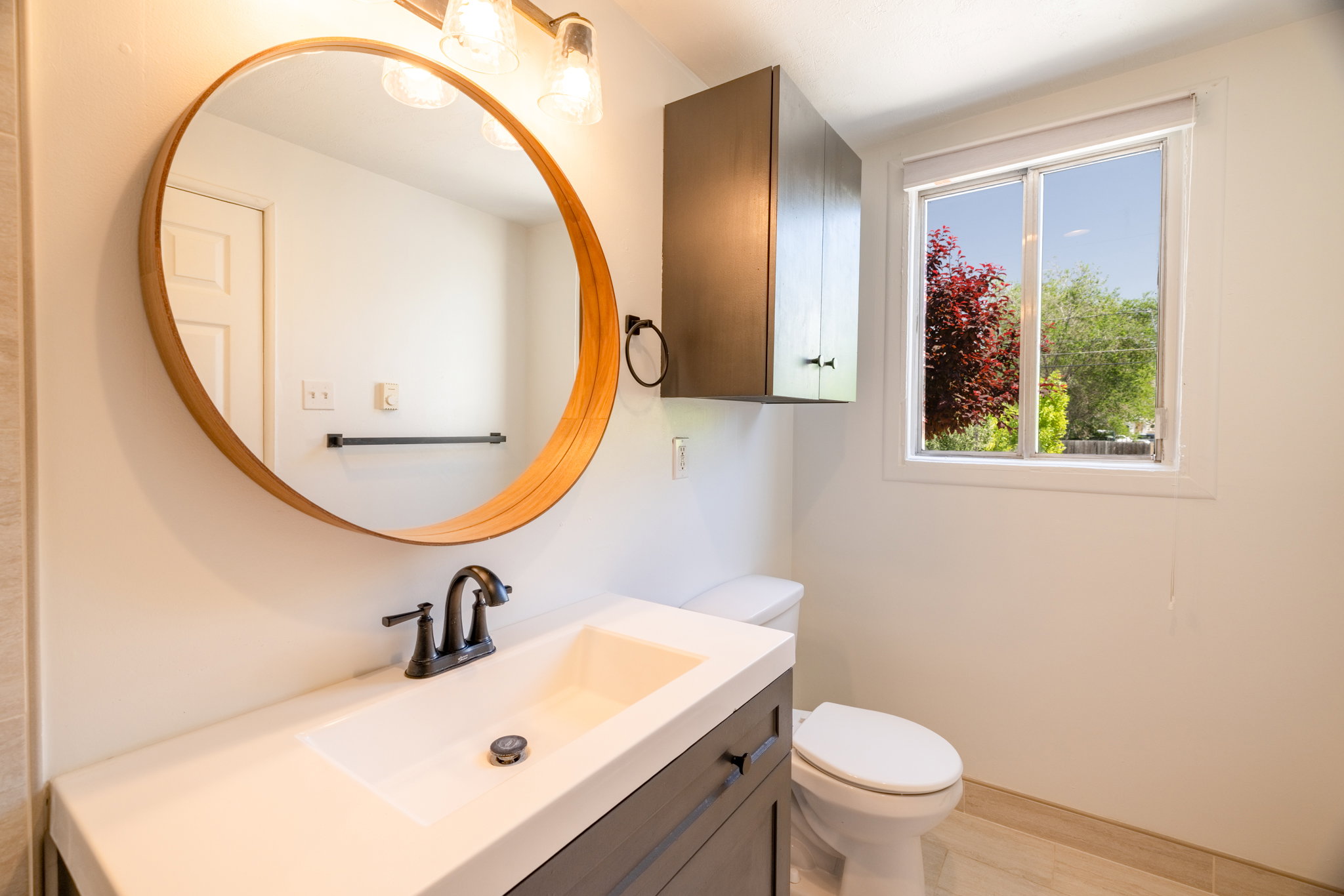 Bathroom featuring a vanity with a white countertop, undermount sink, and dark bronze faucet