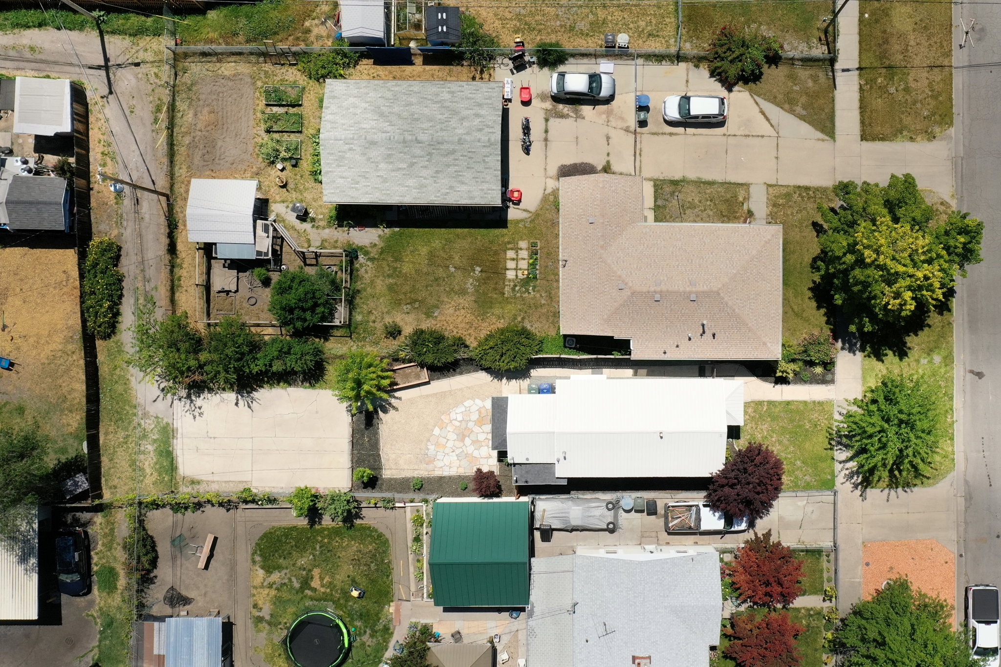 Residential property featuring a rectangular lot, mature trees, and a paved driveway