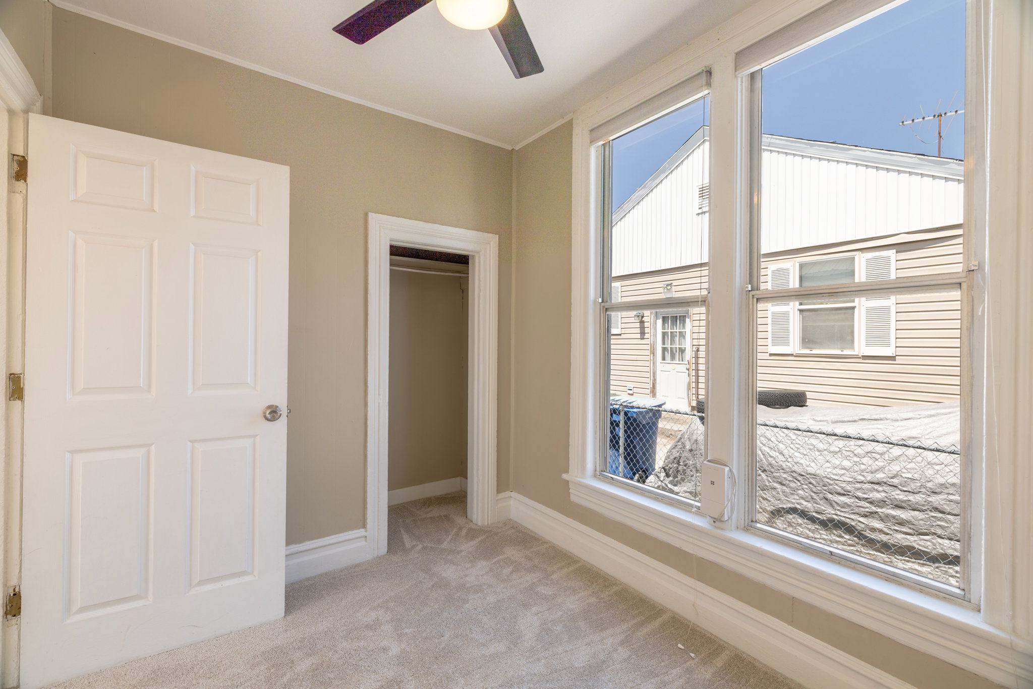 Carpeted interior room featuring light-colored walls and white trim