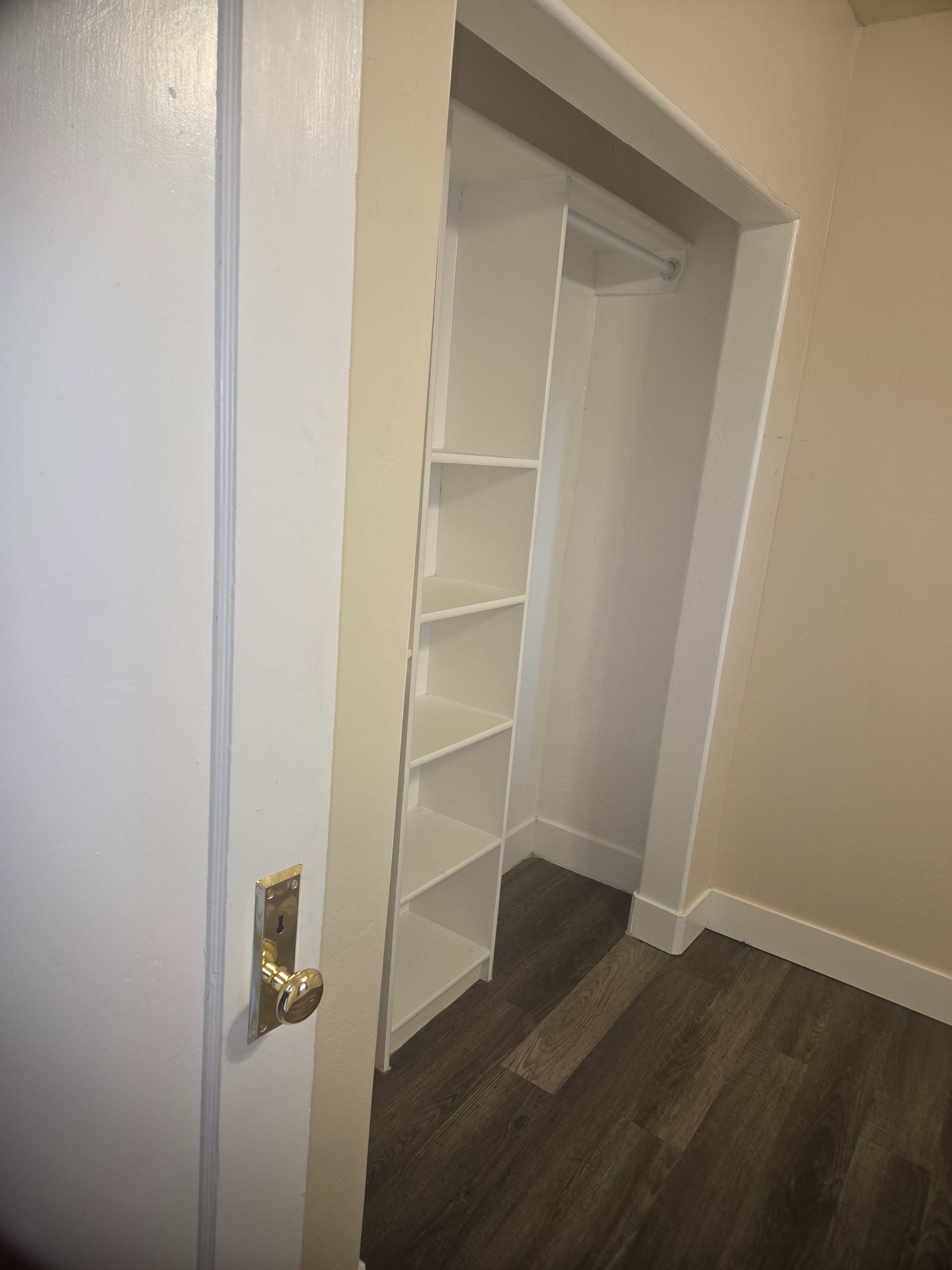 Built-in closet shelving and hanging rod provide storage