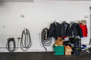 Expansive wall mounted heated garage space with epoxy floors covered with rubber tiles, EV charging station and wall vacuum