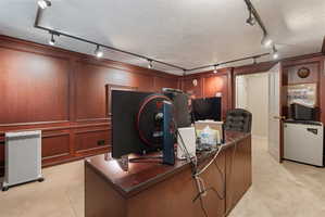 Library office room with cherry wood shelving and paneled walls