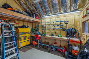 Utility shed interior with workbench, lights, insulated roof, wired with electricity and multiple outlets