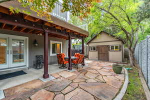 Covered outdoor area, custom cut stone walkway offering direct access via double French doors