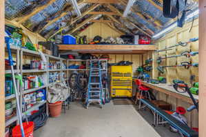 Utility shed interior with workbench, lights, insulated roof, wired with electricity and multiple outlets