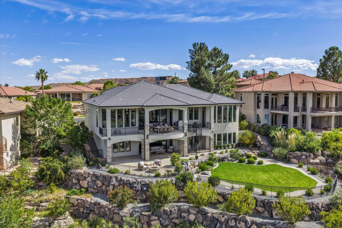 Contemporary multi-level residence featuring a gray tile roof and extensive window lines