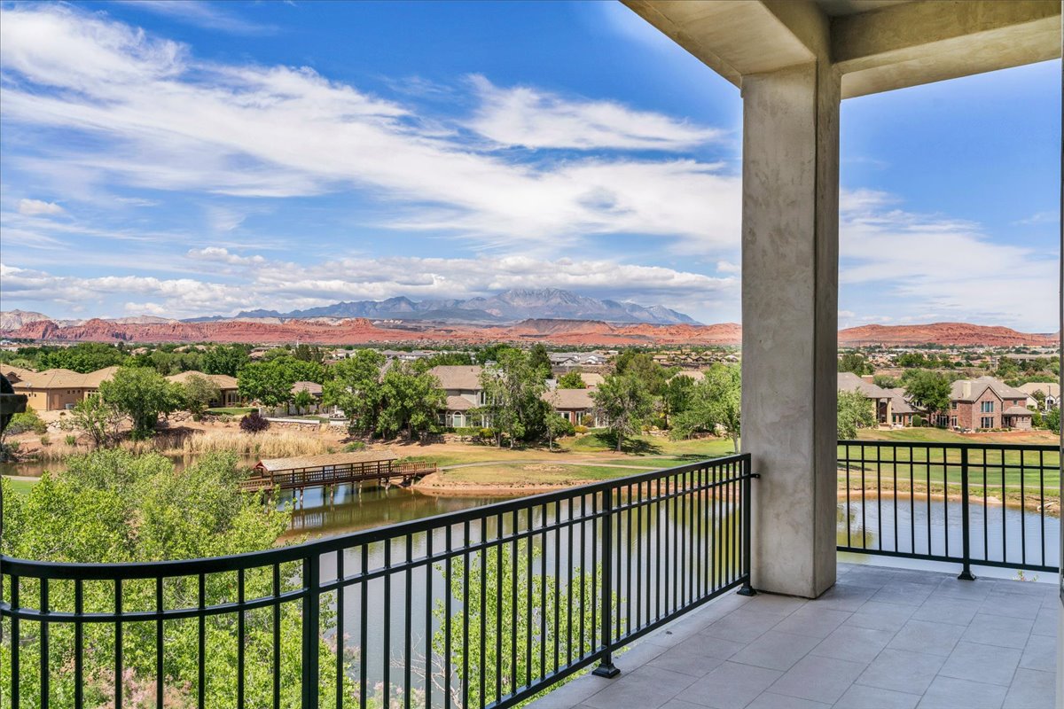 Spacious balcony featuring a tiled floor, robust support columns, and an elegant wrought iron railing