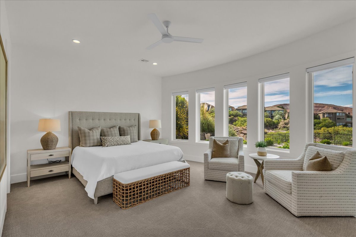 Expansive bedroom featuring a tray ceiling with a ceiling fan, recessed lighting, and a neutral color palette