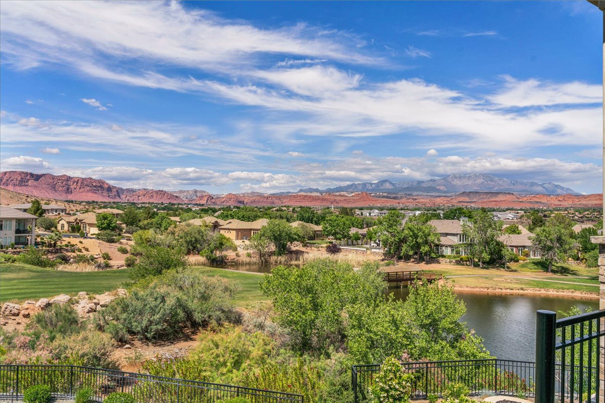 Expansive outdoor scenery featuring a serene lake, a manicured golf course, and distant red rock formations