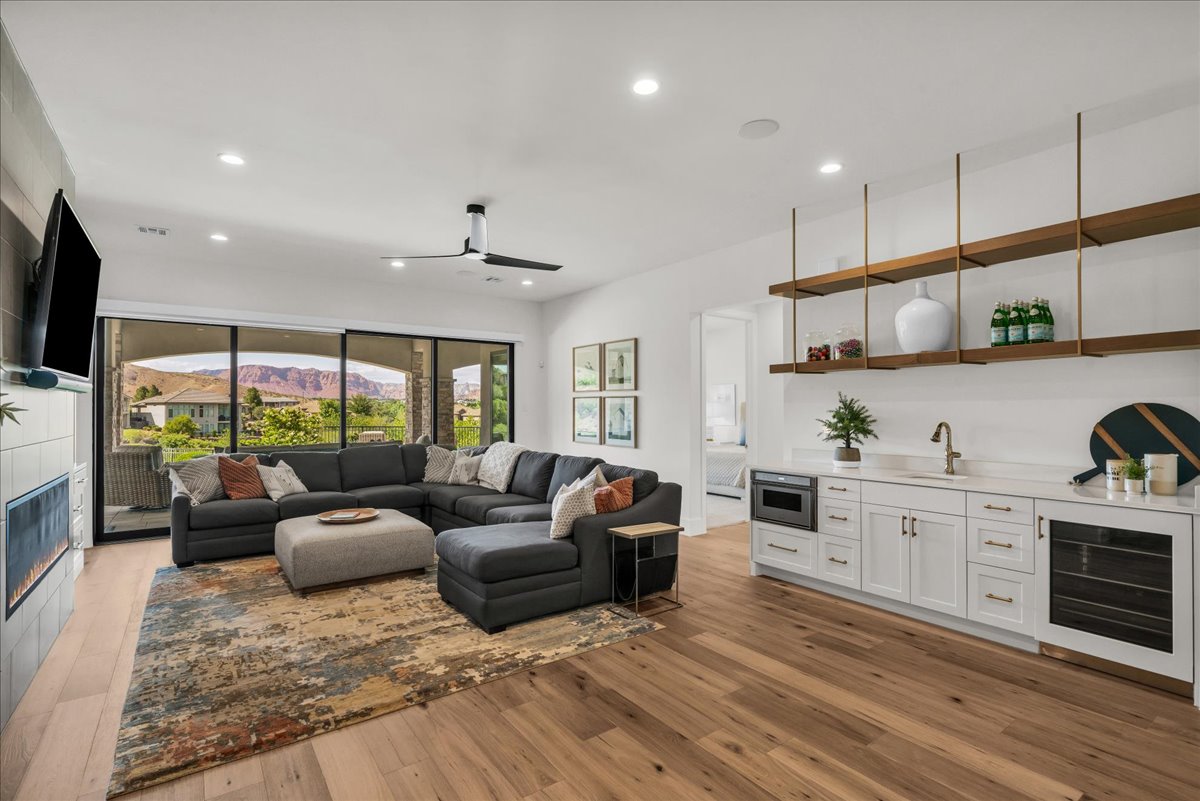 Open-concept living area with wood-finish flooring, a contemporary ceiling fan, and recessed lighting